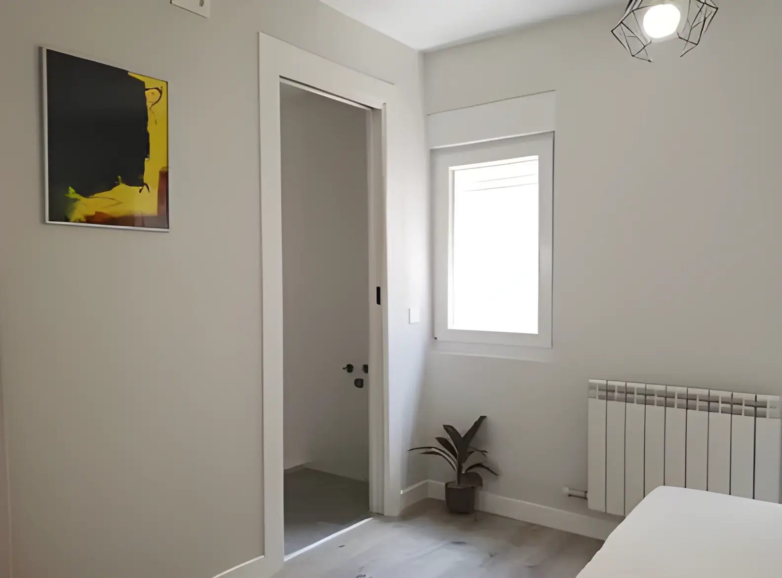 Habitación recién pintada en blanco por Los Pintores Sabadell para comunidad de vecinos